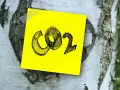Żółta kartka z napisem CO2 przyklejona do kory brzozy. Symbolizuje wpływ emisji na zmiany klimatyczne.
