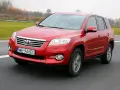 Czerwony SUV do 30 tys. na drodze, z widocznym grillem i tablicą rejestracyjną WE 966EC.