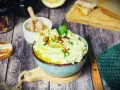 Cremiger Zucchini-Dip mit Pinienkernen und Kräutern, serviert mit geröstetem Brot.