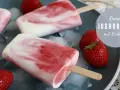 Leckeres Joghurt-Erdbeer-Eis am Stiel, perfekt zum kinder eis selber machen. Frische Erdbeeren und Eiswürfel garnieren das süße Rezept.