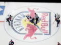 Hokeiści walczą o krążek na lodowisku z logo Red Bull. W hokeju są trzy tercje, a zawodnicy szykują się do kolejnej.