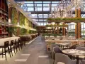 Interior de bar moderno con barra de mármol, estanterías de vino, vegetación y lámparas de araña. Ideal para la licencia apertura bar.
