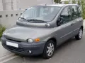 Szary Fiat Multipla, często uznawany za najbrzydsze auto na świecie, stoi na ulicy. Jego nietypowy kształt przyciąga wzrok.