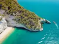 Widok z lotu ptaka na skaliste wybrzeże Włoch z plażą i turkusową wodą.