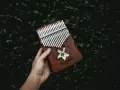 Dłoń trzyma kalimbę z ozdobnym kwiatem i napisem. Dowiedz się, jak grać na kalimbie i twórz magiczne melodie.