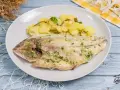 Dorada al horno con patatas panaderas, un plato principal delicioso y saludable.
