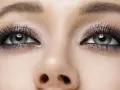 Oczy z makijażem typu smokey eyes, podkreślone długimi rzęsami i błyszczącym cieniem.