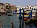 Venice canal with gondola, Rialto Bridge, and buildings.