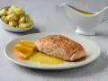 Filete de salmón a la naranja, servido con gajos de naranja y una salsa dorada. Acompañado de patatas pequeñas.