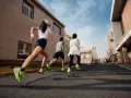 Tre persone corrono un'ora al giorno in città, con scarpe da ginnastica verdi brillanti che spiccano.