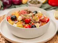 Ein bunter Kartoffelsalat mal anders: mit Feta, Tomaten, Oliven und Kapern, appetitlich gewürzt.