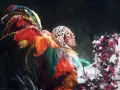 Elton John in einem extravaganten Federkostüm, das an einen Pfau erinnert. Seine ikonischen Elton John Outfits sind legendär.