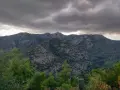 Góry Troodos pod burzliwym niebem. W oddali na szczycie widać charakterystyczną budowlę.