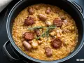 Arroz a la zamorana en paellera con chorizo, salchichas y hierbas aromáticas.