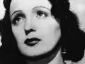 Edith Piaf, ikona francuskich piosenek, z charakterystycznym spojrzeniem i burzą ciemnych włosów.