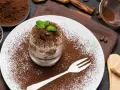 Pyszne tiramisu w pucharku, posypane kakao i kawą. Idealne desery co zamiast surowych jaj, z miętą i biszkoptami.