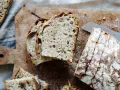 Frisches Brot mit Nüssen, perfekt **mit Dampf gebacken**, liegt auf einem Holzbrett.