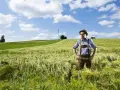 Un homme en culotte de peau et chapeau se tient dans un champ d'orge. Son nom, Hoffmann, pourrait avoir une origine juive, évoquant une histoire ancestrale.
