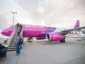 Pasażerowie wsiadają do różowego samolotu Wizzair. Czy można odwołać lot?