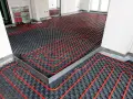 Instalación de un sistema de calefacción por suelo radiante, con tuberías rojas serpenteando sobre una base negra. Preparando un suelo refrescante para el confort.
