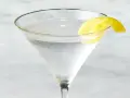 Chłodny martini z ginem, ozdobiony skórką cytryny, czeka na degustację.