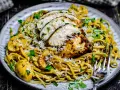 Cremiges Chicken Alfredo mit Pilzen, garniert mit Parmesan und Petersilie. Ein köstliches Gericht, das Lust auf mehr macht.