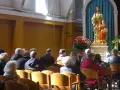 Ludzie w kościele, przed ołtarzem z figurą św. Józefa i Dzieciątka Jezus. W tle bukiet czerwonych róż. Sanktuarium Matki Bożej Częstochowskiej.