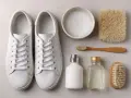 Un paio di scarpe da ginnastica bianche, spazzole, sapone e dentifricio per pulire la gomma bianca delle scarpe.