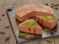 Deliziosa bavarese al cioccolato, spolverata di cacao e decorata con menta fresca. Due fette sono già pronte per essere gustate.