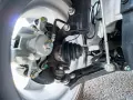 Parti di un'auto: pinza freno, giunto sferico e semiasse con soffietto integro, pronto per la sostituzione in caso di rottura semiasse.