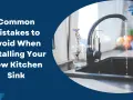 Water flows into a new black kitchen sink. Learn common mistakes to avoid when installing your new kitchen sink.