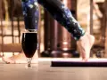 Kreatyna a alkohol: czy można połączyć trening z piwem? Nogi w legginsach i szklanka ciemnego piwa na pierwszym planie.