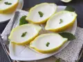 Fyra citroner fyllda med krämig dessert, garnerade med mynta. Perfekt för enklaste julbaket.
