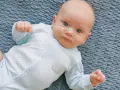Niebieskie oczy niemowlaka patrzą wprost. Cudowny widok, kiedy dziecko przesypia noc.