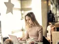 Kvinna skriver tack mail efter intervju på sin laptop vid ett bord med en tekanna.