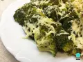 Brocoli al horno gratinado con queso, servido en un plato blanco.