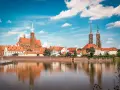 Wrocławskie Ostrów Tumski z katedrą i kościołami, odbijające się w wodzie. W tle widać budynki, które mogłyby pomieścić muzeum sztuki mieszczańskiej.