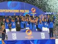 Drużyna w niebieskich strojach świętuje zdobycie Superpucharu Polski, unosząc trofeum i ciesząc się z wygranej wśród konfetti.