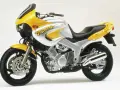 Żółto-srebrny motocykl Yamaha TDM 850 z charakterystycznym napisem "TDM" na baku. Gotowy na przygodę!