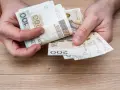 Ręce liczą banknoty 100 i 200 zł. To na pewno wystarczy na wczasy pod gruszą i jeszcze zostanie!