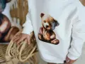 Biała bluza Moschino z uroczym misiem w stylu vintage. Dziecko trzyma się wiklinowego koszyka.