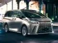 Srebrny van Lexus LM 350h na nocnej ulicy z rozmytym tłem.