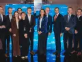 Grupa ludzi na scenie, wśród nich Janusz Sowa, odbiera dyplom. W tle niebieskie banery z logo Puls Farmacji.