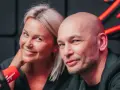 Tomasz Wygoda z żoną i dziećmi, uśmiechnięci przed mikrofonem.