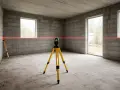 Laser krzyżowy na statywie wyznacza linię na ścianach z bloczków. Czy najpierw tynki czy wylewki? To pytanie, na które odpowiedź pomoże wyznaczyć ten laser.