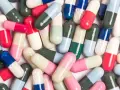 Kolorowe kapsułki leków, które mogą wywołać pieczenie pochwy po antybiotyku.