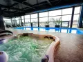 Relaks w hotelowym spa w Białymstoku: jacuzzi z bąbelkami i basen z widokiem na miasto.