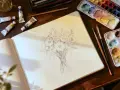 Un carnet ouvert montre un croquis de fleurs. Autour, des tubes de peinture et des pinceaux suggèrent ce avec quoi dessiner sur une toile avant de peindre.