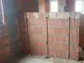 Wykonano bruzdowanie pod kable w ścianie z pustaków ceramicznych. Widoczne są puszki instalacyjne.