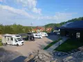 Kampery i samochody kempingowe zaparkowane na placu, gotowe na przygodę w Kudowie-Zdroju.
